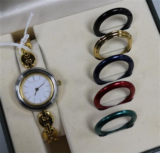 A Gucci ladies wristwatch with interchangeable bezels and papers, boxed.